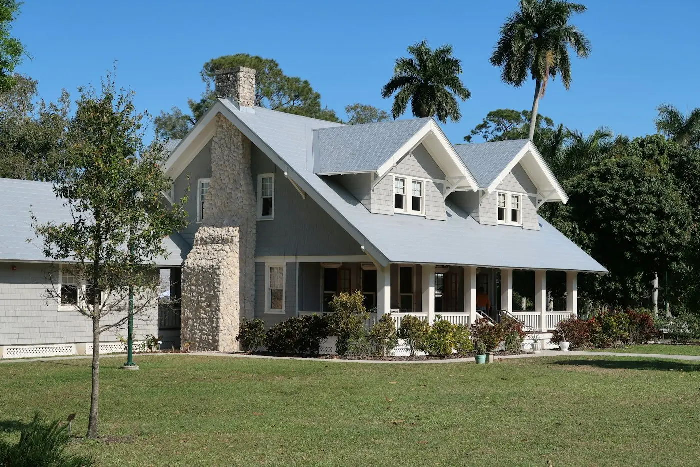 Craftsman house with a stone chimney and a deep porch