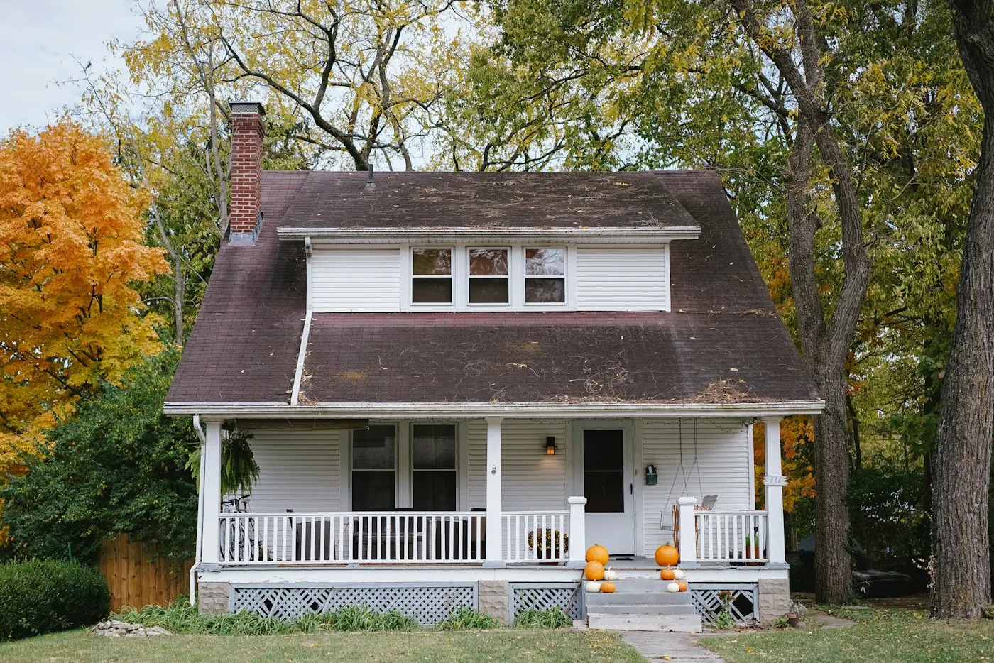 Wood privacy fence beside a white American house with a front porch