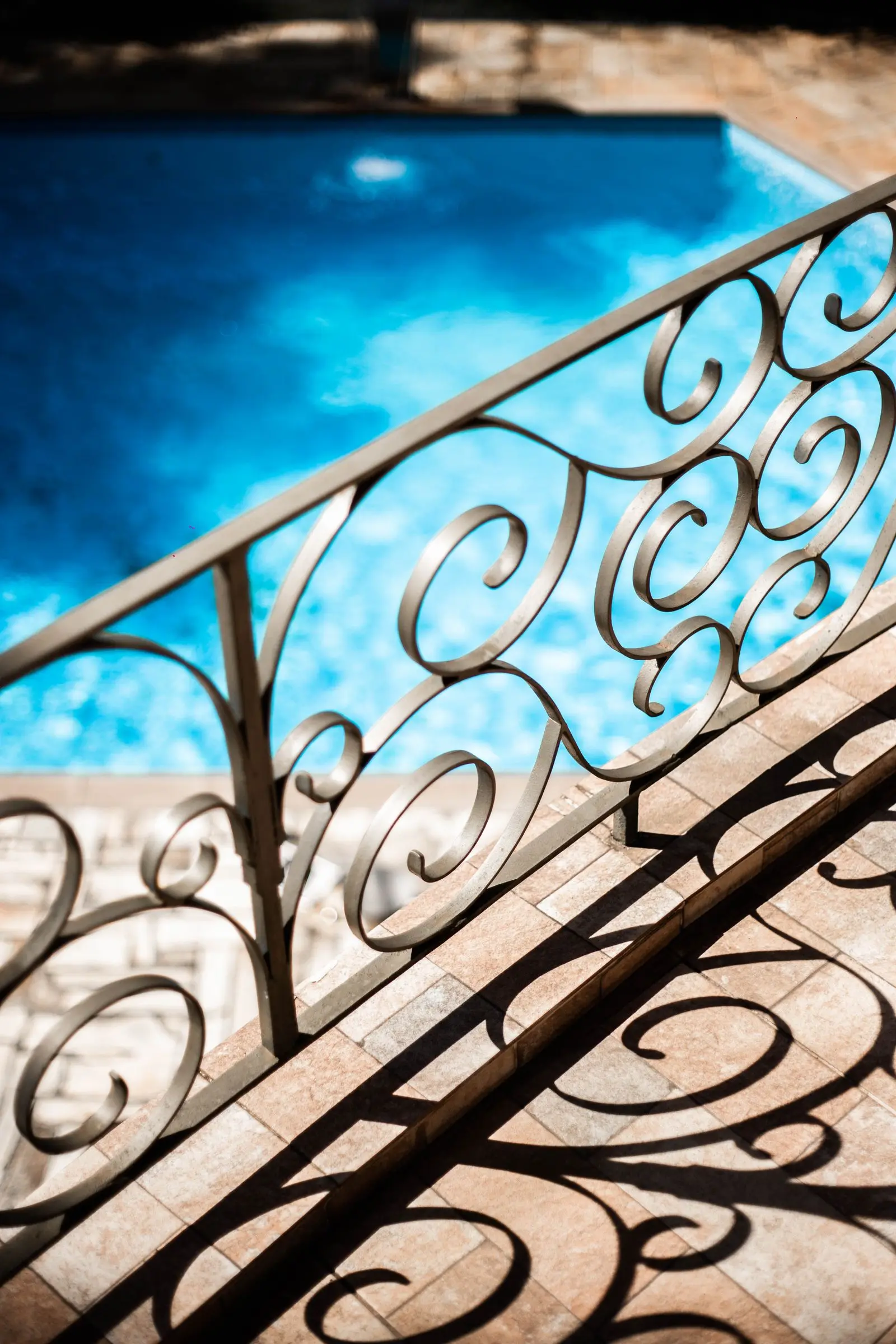 Ornamental metal beside a pool, the kind of line a gate has to match